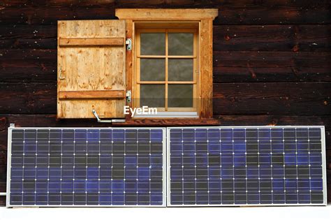 Solar panels on log cabin wall | ID: 84914816