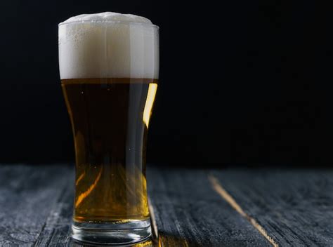 Premium Photo | Glass of lager on a dark background