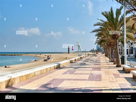 El Campello, Spain - May 22, 2018: Palm-lined promenade and beach of El Campello. Alicante ...