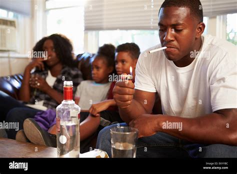 Parents Sit On Sofa With Children Smoking And Drinking Stock Photo - Alamy