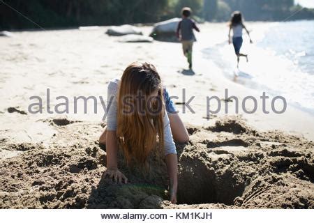 Girls digging in sand on beach Stock Photo: 61221169 - Alamy