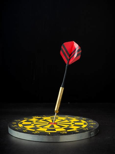 Premium Photo | Dart arrow with board on black granite