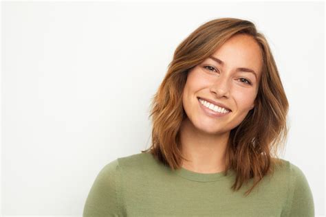 portrait of a young happy woman smiling on white background - Goodman Family Dentistry