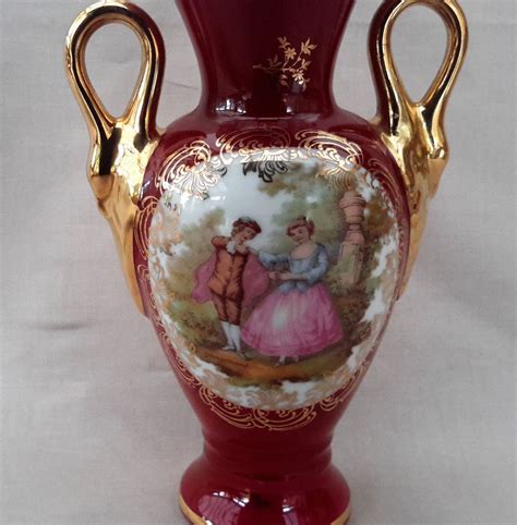 a red and gold vase with figures painted on it