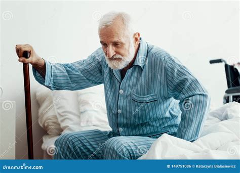 Old Sick Man with Grey Beard and Hair Wearing Blue Pajamas and Sitting on Bed at Home Stock ...