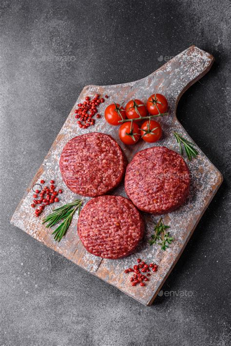 Fresh raw ground beef burger patty with salt and spices Stock Photo by ...