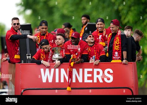 Liverpool players with the Emirates FA Cup trophy on an open-top bus ...