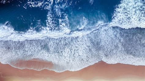 Splashing ocean waves washing sandy beach during tide · Free Stock Photo