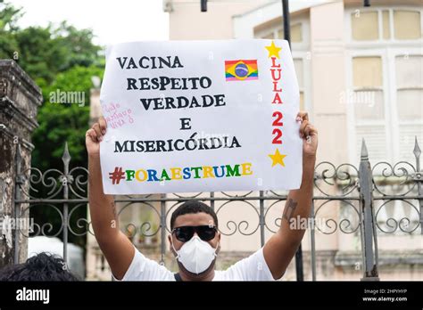 Brazilian in a mask with a poster protests against President Jair ...