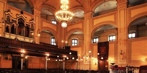 an empty church with chandeliers and pews