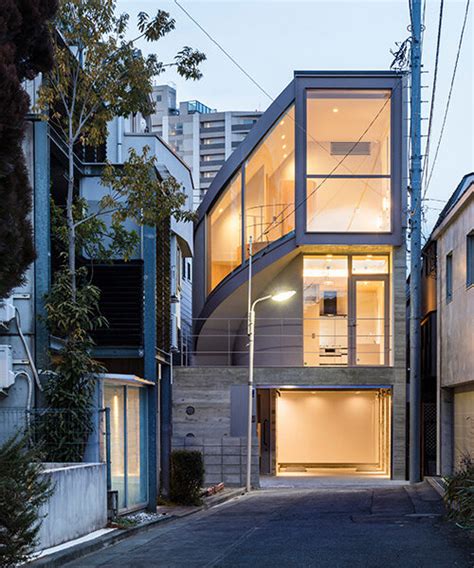 curved glass-enclosed staircase peeps out of tokyo house that 'dances in the city'