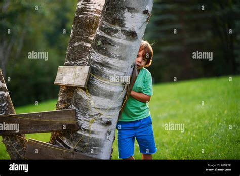 Person hiding behind a tree hi-res stock photography and images - Alamy