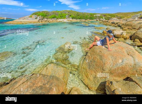 Carefree woman looking the calm turquoise waters of Madfish Bay in William Bay National Park ...