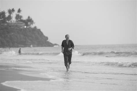 Premium Photo | A man is walking on the beach in black and white