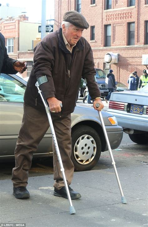 Robert De Niro looks older with all-white hair as he hobbles on crutches in New York... but it ...