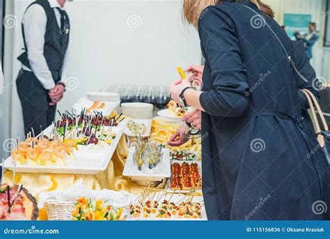 Catering Buffet Table with Food and Snacks for Guests of the Event. Group of People in All You ...