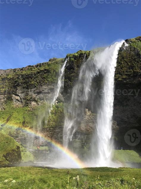 A rainbow in front of Seljalandsfoss waterfall on the southern coast of ...