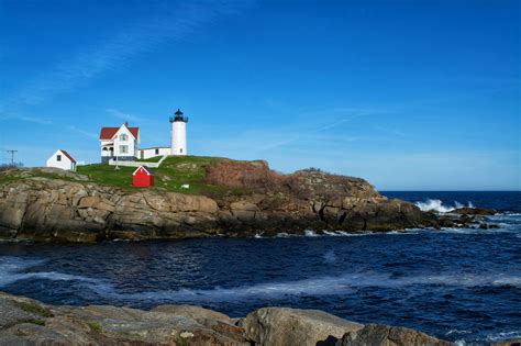 a lighthouse on top of a rocky cliff near the ocean