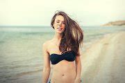 young smiling woman in black bikini on sea background | People Images ~ Creative Market