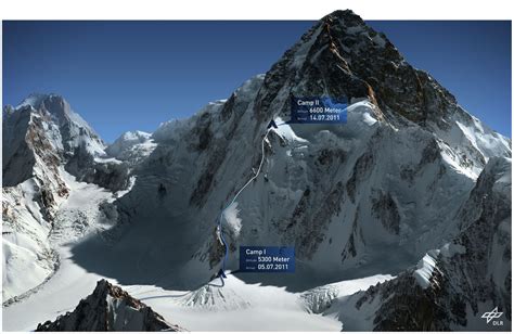 the top of a snowy mountain with blue signs pointing to different locations in front of it