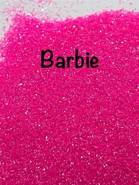 the word barbie written in black on a pink background with glitter and sparkles around it