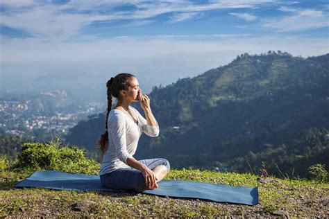 Woman practices pranayama in lotus pose outdoors | Pranayama, Bhastrika ...