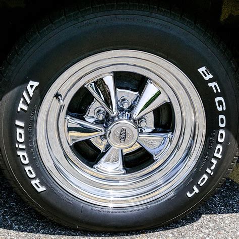 the tire of a car that is parked on the side of the road with writing on it