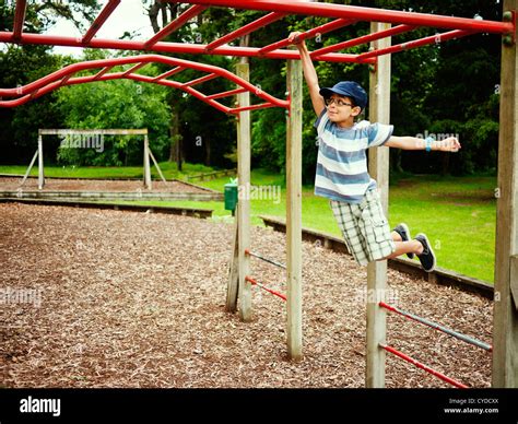 Children swing on monkey bars in adventure playground, New Zealand Stock Photo - Alamy