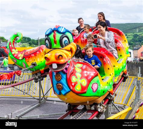 family enjoying a fun day out on the fairground rides at the funfair in ...