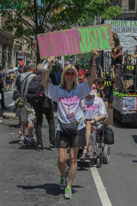 A Protester Holding a Cardboard Sign on a Street · Free Stock Photo