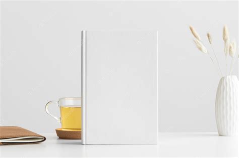 Premium Photo | White book mockup with a lagurus and workspace accessories on a white table