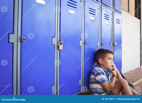Boy Talking on Mobile Phone while Sitting by Lockers Stock Image - Image of knowledge, side ...