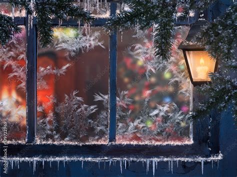 Beautiful Christmas window. Snow, lights a lantern, icicles. Through the window you can see the ...