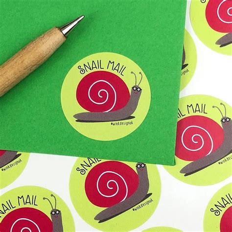 the snail mail stickers are next to a pen on top of some green envelopes