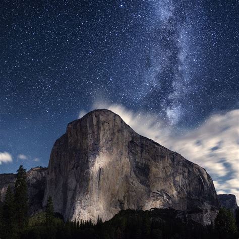 the night sky is filled with stars and clouds above a mountain peak in ...