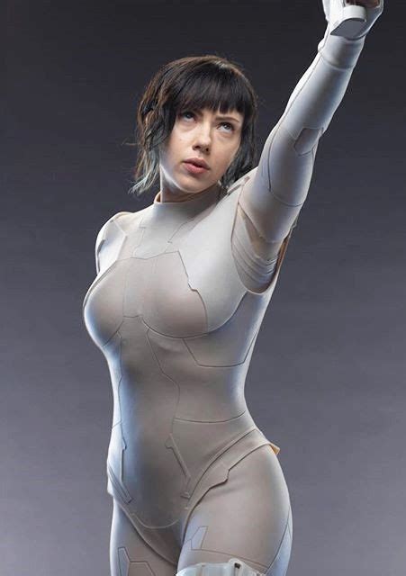 a woman in a body suit holding a cell phone up to the sky with her right hand