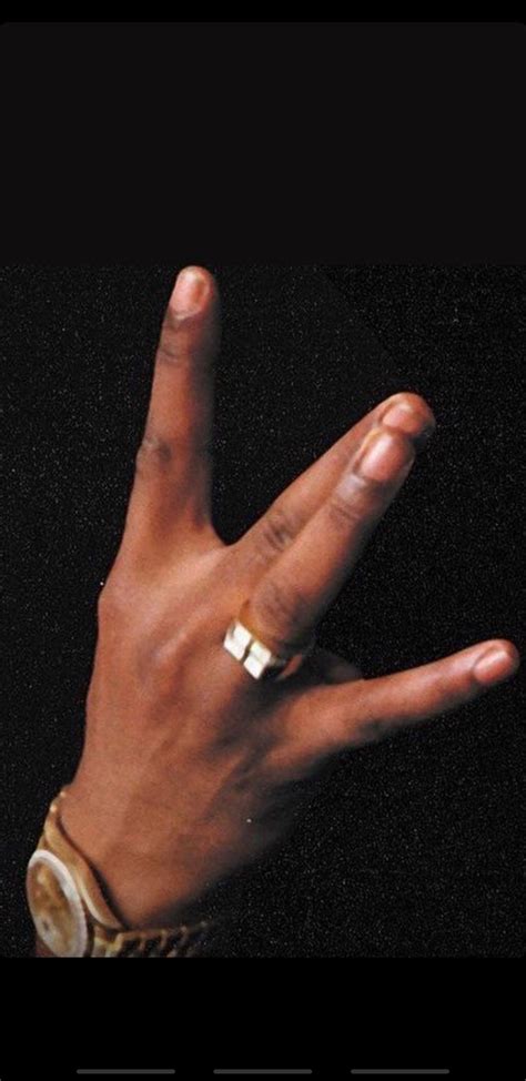 a person's hand with a gold ring on it and the word love is in the middle