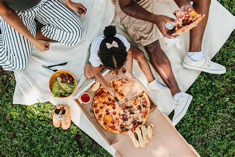 "A Family Of Three Having A Picnic In The Park & Eating Pizza" by Stocksy Contributor "Kristen ...