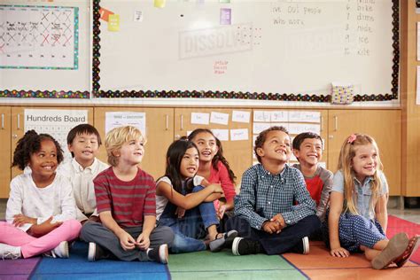 Elementary school kids sitting on classroom floor - Stock Photo - Dissolve