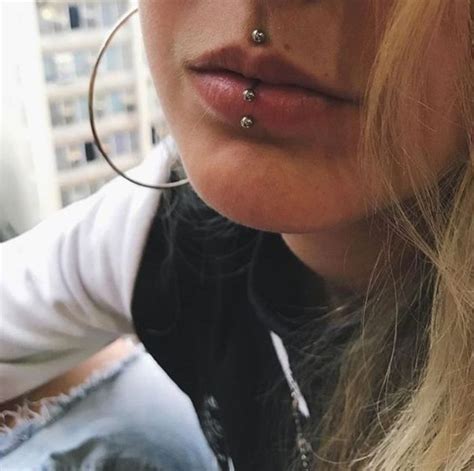 a woman with piercings on her nose looking at the camera