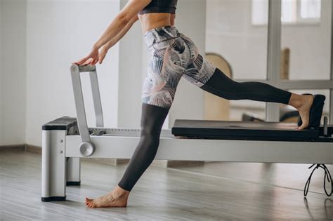 Free Photo | Woman practising pilates in a pilates reformer legs close up