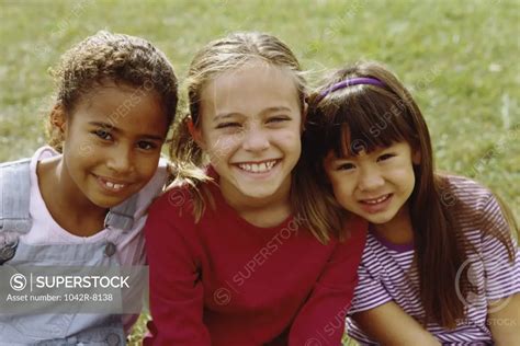 Portrait of three girls smiling - SuperStock