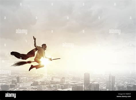 Young businessman flying on broom high in sky Stock Photo - Alamy