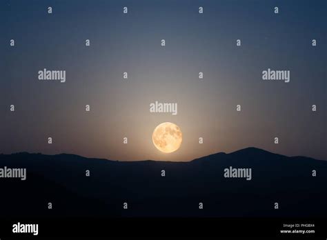 Big moon rising on night sky Stock Photo - Alamy