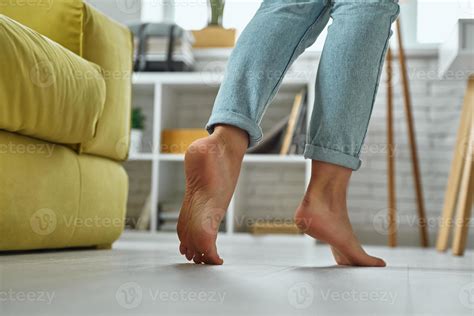 Close-up of barefoot woman walking on wooden floor at home 10148573 ...