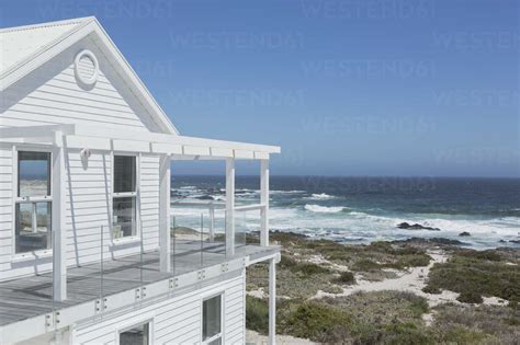 White beach house with ocean view under sunny blue sky stock photo