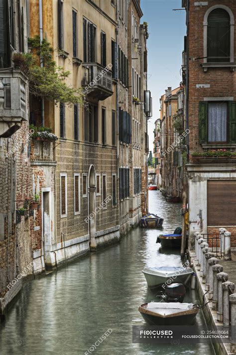 Houses and boats on water along canal, Venice, Italy — anchored, city ...