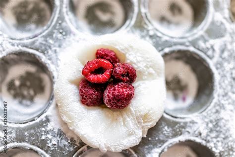 Piece of mochi sticky glutinous rice cake dusted with starch flour to make dessert in muffin pan ...