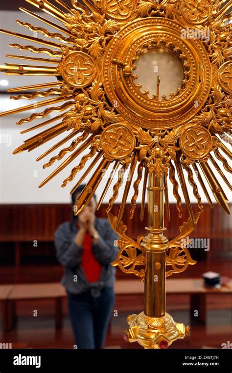 The Blessed Sacrament in a monstrance. Eucharist adoration. Woman ...