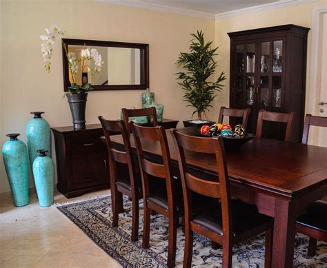 a dining room table with chairs and vases
